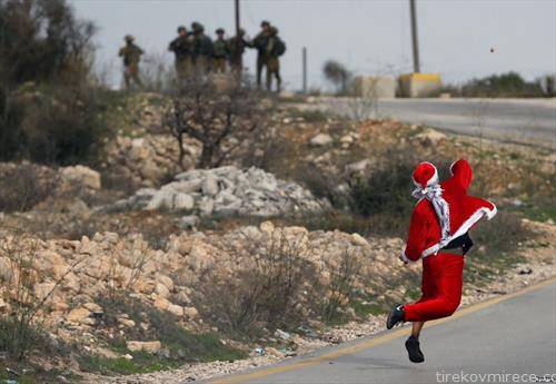 Палестинец како Дедо Мраз, фрла камења по Изралеската полиција