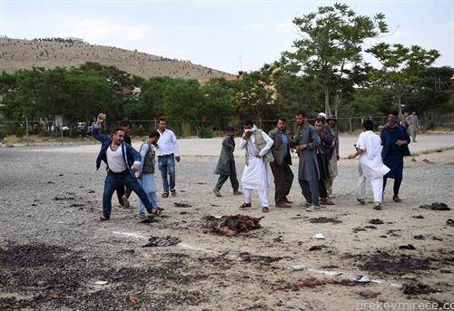 бесен жител на  Кабул со камен по остатоците од телот на бомбашот убиец