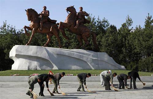 северно Корејци чистат пред споменикот на Ким Ил сунг