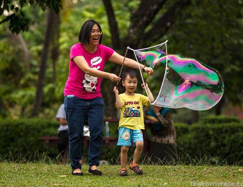 Жена со дете додека прават балони од сапуница на Денот на Малезија 