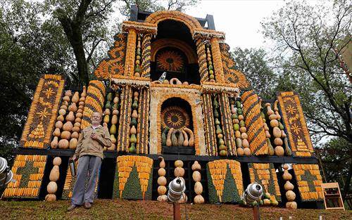 Парагвајскиот уметник Коки Руиз позира пред олтарот што за првпат го изгради со пченка, тикви и кокоси,