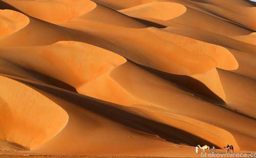 луѓе минуваат по пустина во Судиска Арабија, 