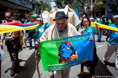 Човек со плакат во рацете учествува на маршот против климатските промени во Богота, Колумбија.