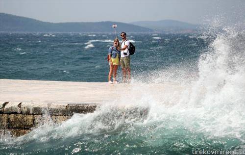туристи прават саелфи во задар а морето немирно