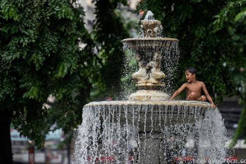 деца се разладуваат во фонтана во  Манила Филипини