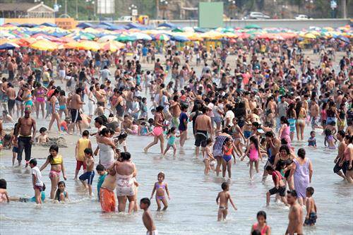 , Посетители се забавуваат и бањаат на плажата Коста Верде во Лима, Перу