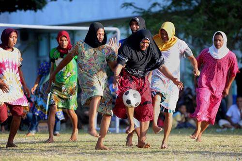 мажи преоблечени во жени играат фудбал во Индија