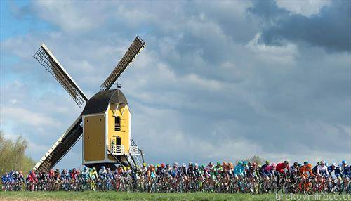 велосипедисти пред ветерницата Хубертус за време на Амстел Златната трка во Бек, Холандија