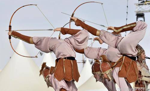 киргиски танчери, стрелаат со лак со нога, на фестивал во Ријад